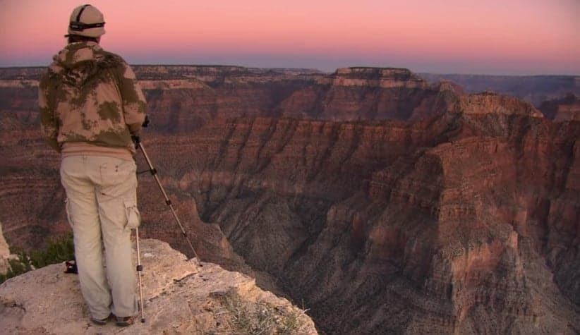 a man standing in front of grand canyon in arizona