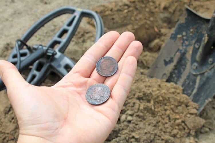 man finds a coin while metal detecting