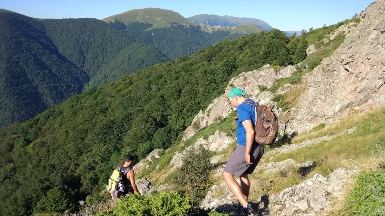 two friends walking on a rocky mountain terrain