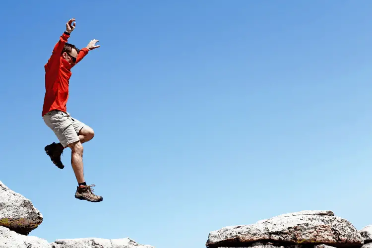 a man jumping off a rock