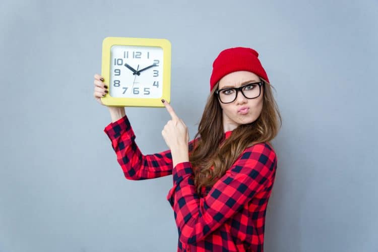 woman pointing at a clock