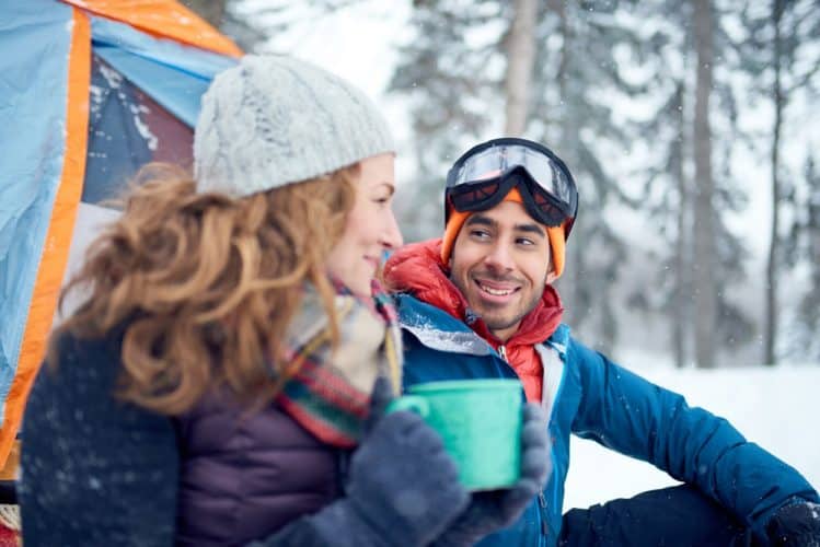 a couple drinking hot tea at camp