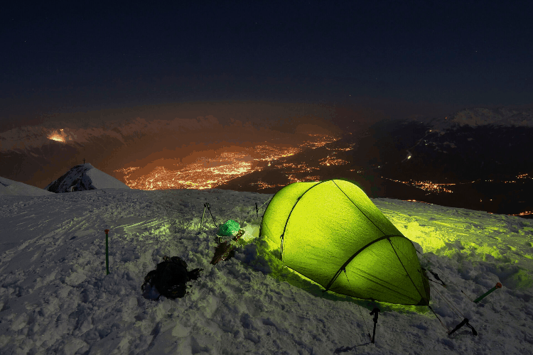 a warm tent up on a hill at night