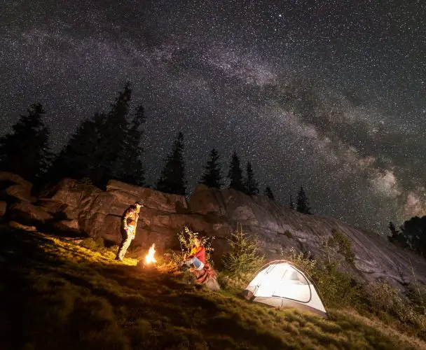 Night summer camping in the mountains under night starry sky
