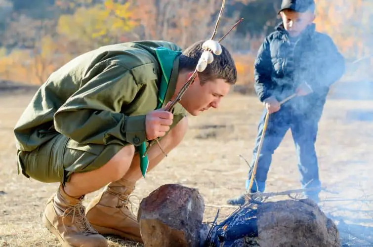 a man blowing on a campfire