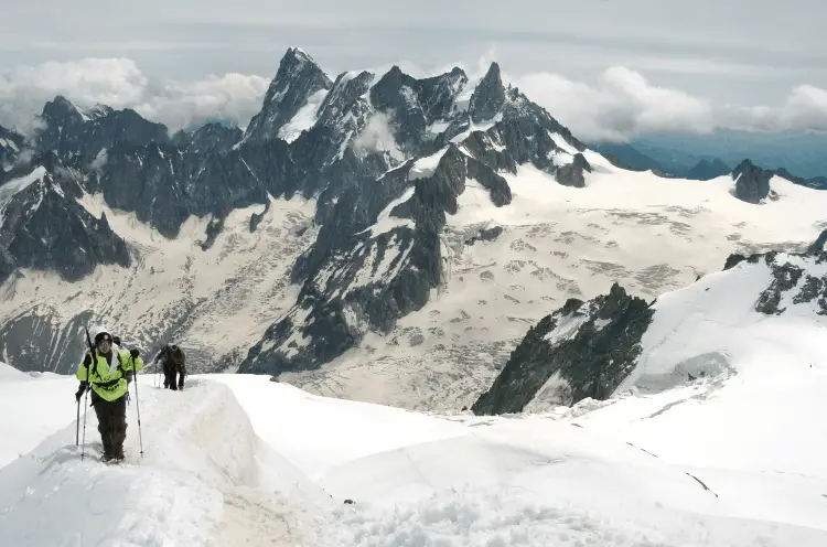 group of hikers walking on a snowy peak