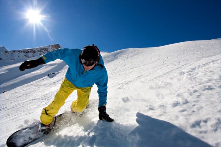 a hiker wearing ski pants climbing a steep hill