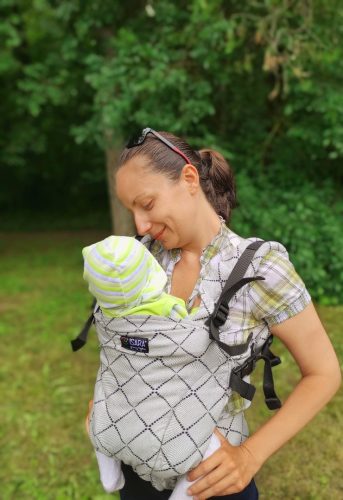 a baby in an ergonomic child carrier