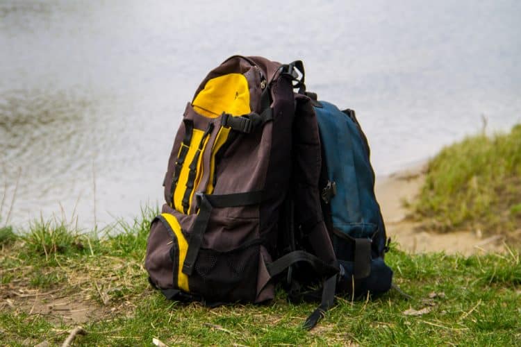 a backpacking backpack next to a tree