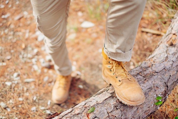 Man crossing tree trunk