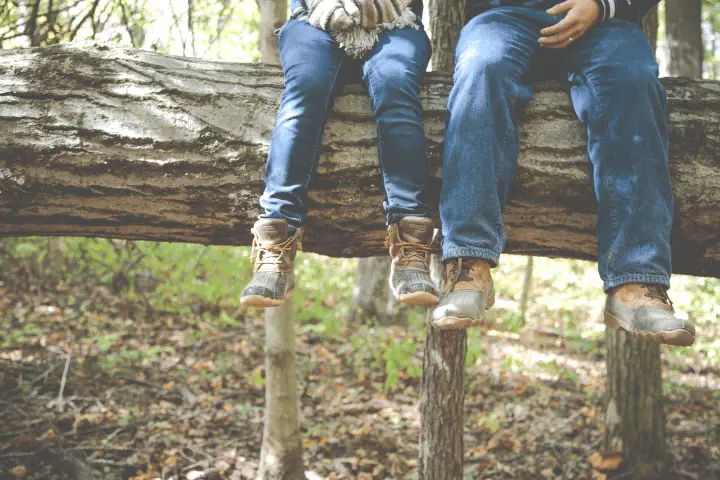 two men seating on a tree trunk