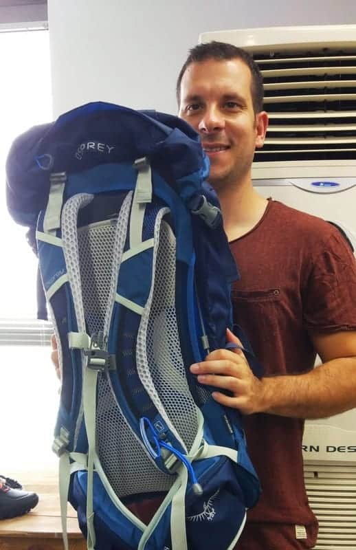 me, holding an Osprey backpack