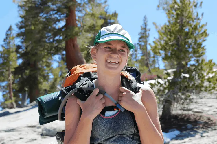 a girl smiling while backpacking