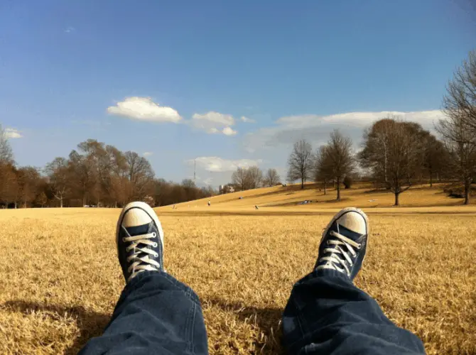 man wearing sneakers laying on the grass